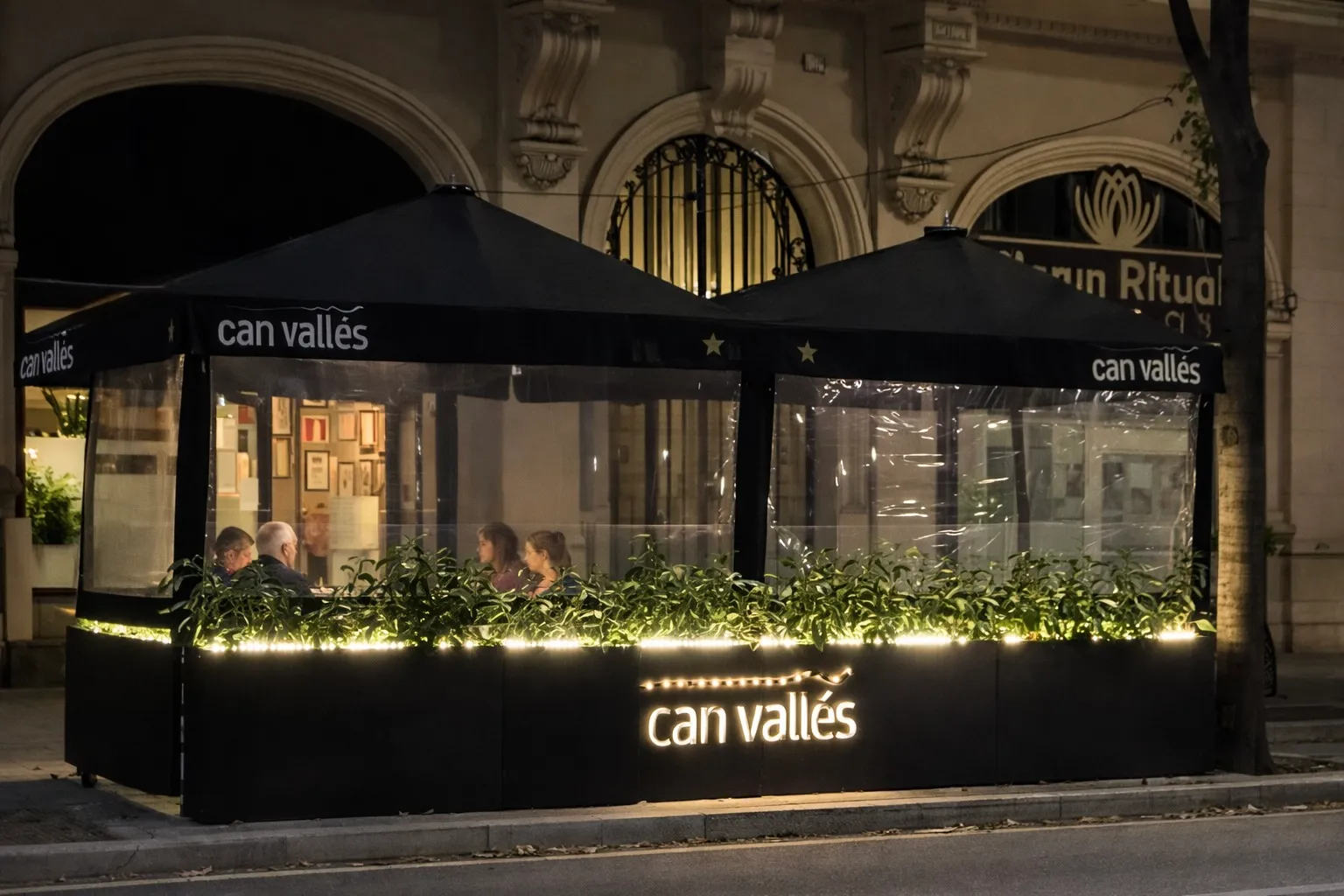 Cerramiento de terraza de restaurante con jardineras iluminadas y laterales transparentes en invierno